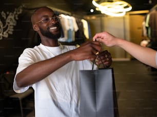 a man is holding a shopping bag and smiling