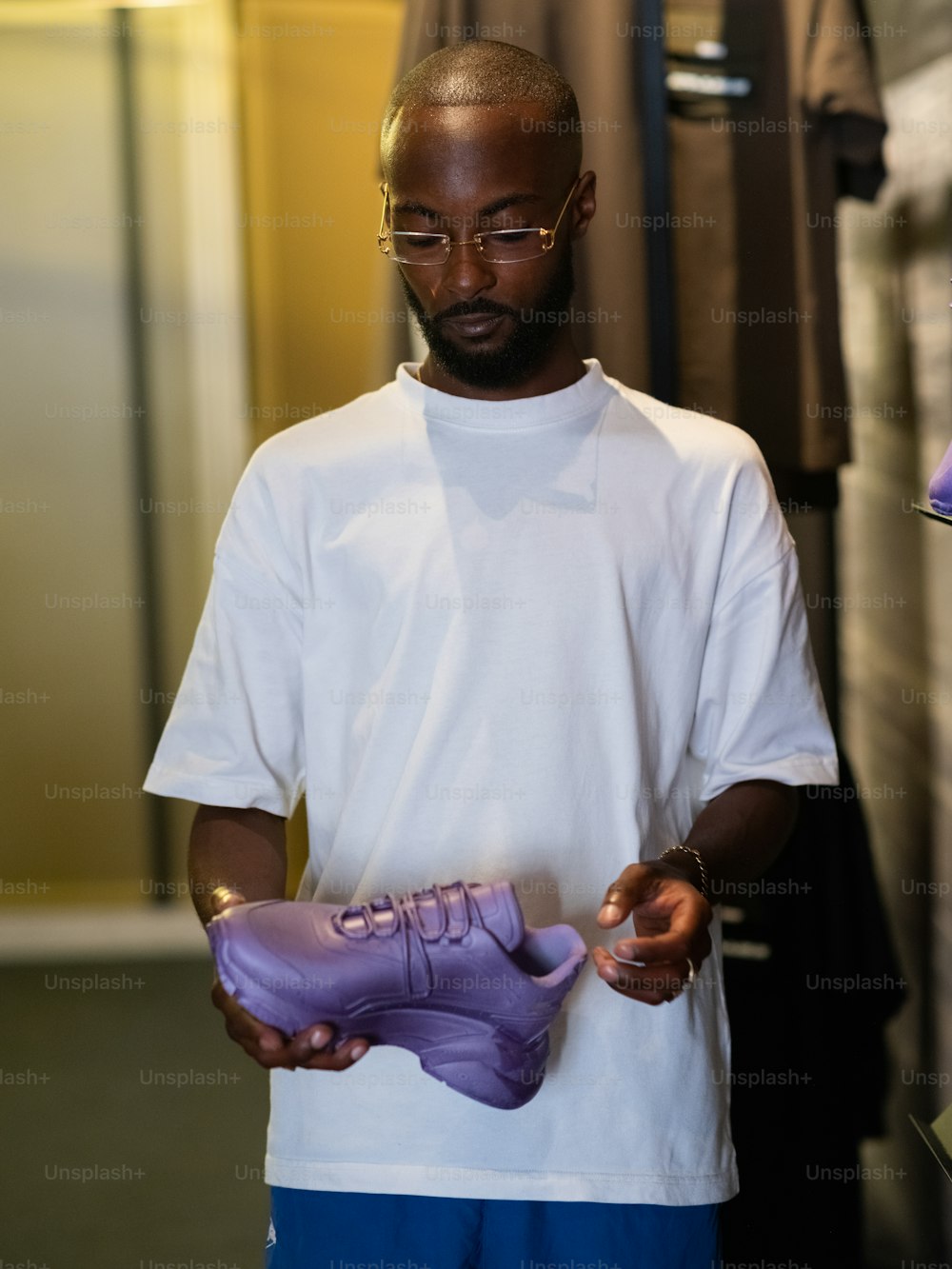 um homem segurando um par de sapatos roxos