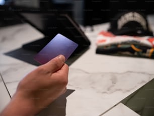 une personne tenant une carte violette sur une table