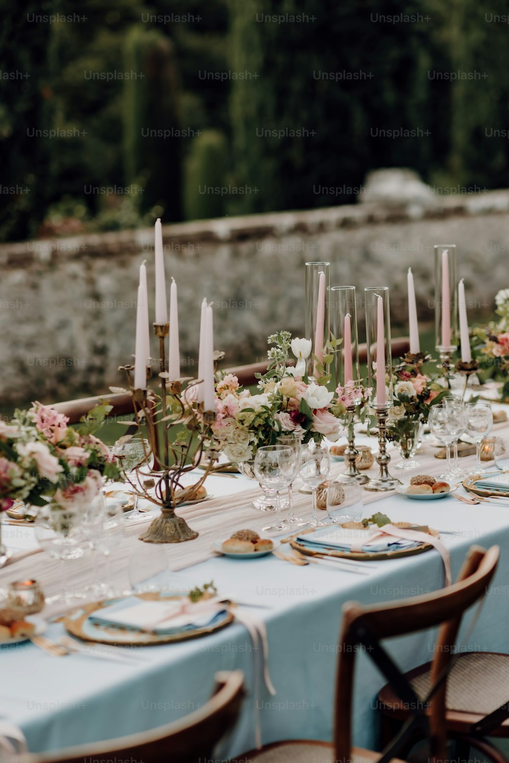 a long table with a blue table cloth and flowers on it