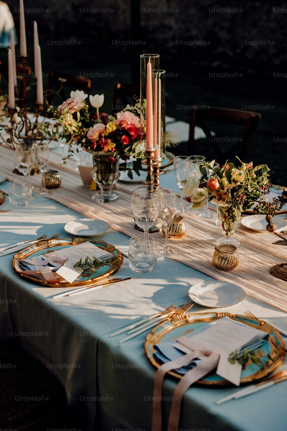 eine lange Tafel mit Tellern und Gedecken