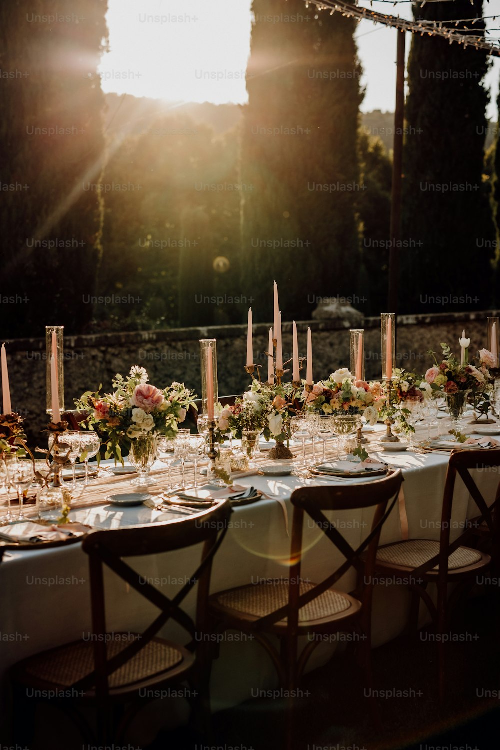 Una mesa larga con muchas flores y velas