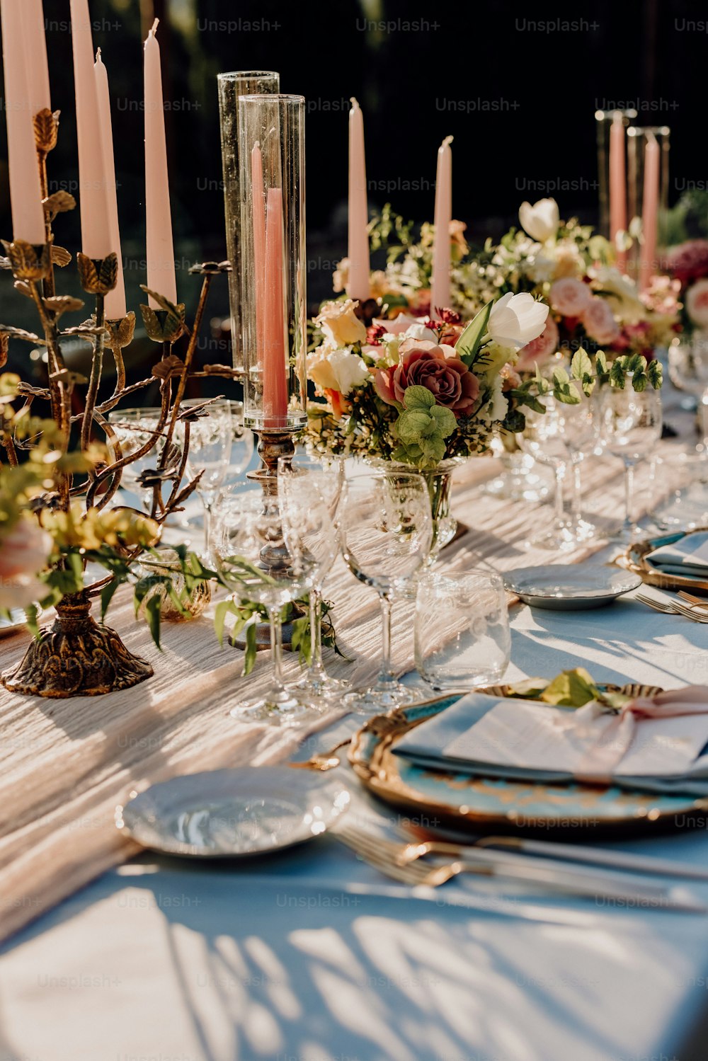 uma mesa comprida com velas e flores