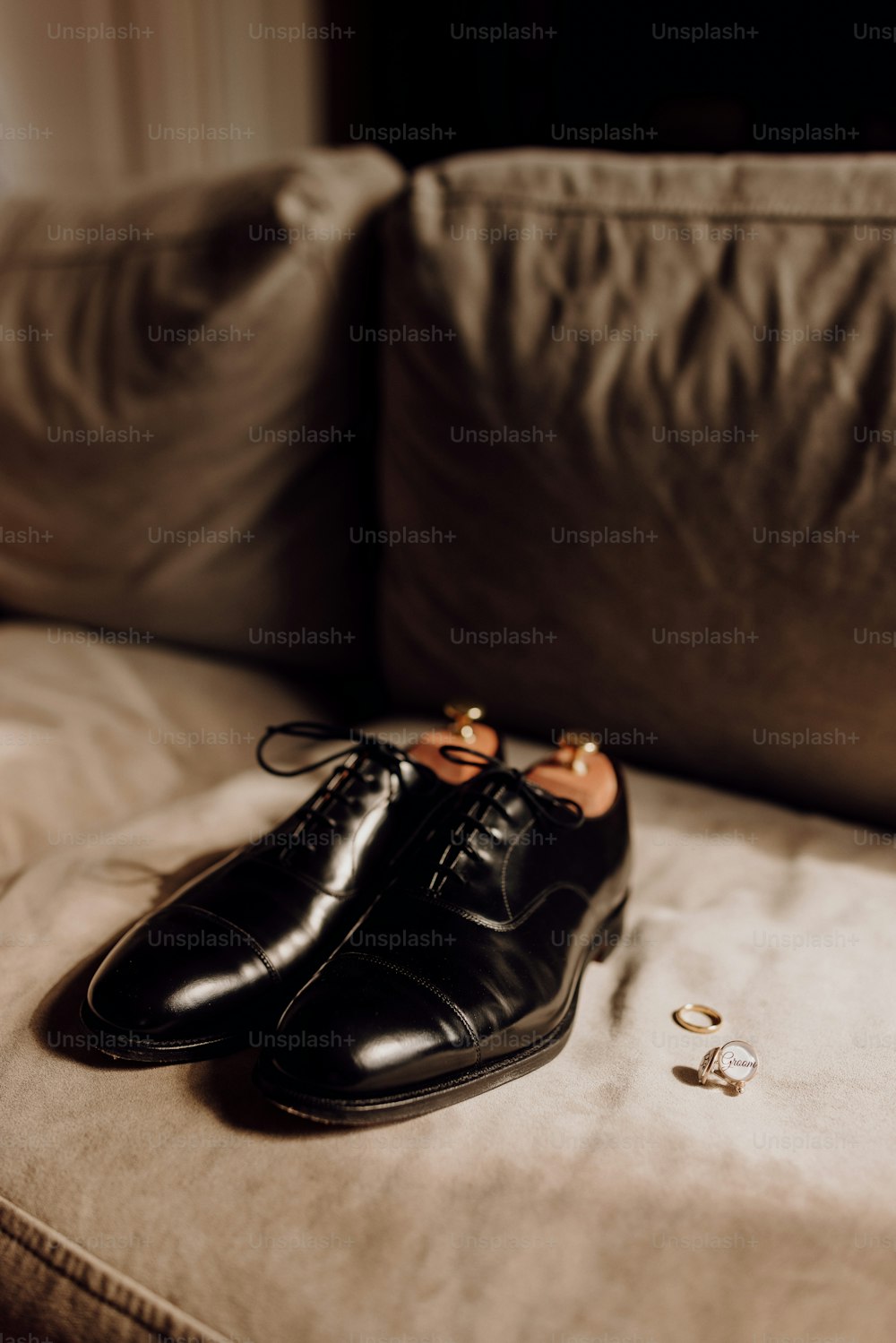 a pair of black shoes sitting on top of a couch