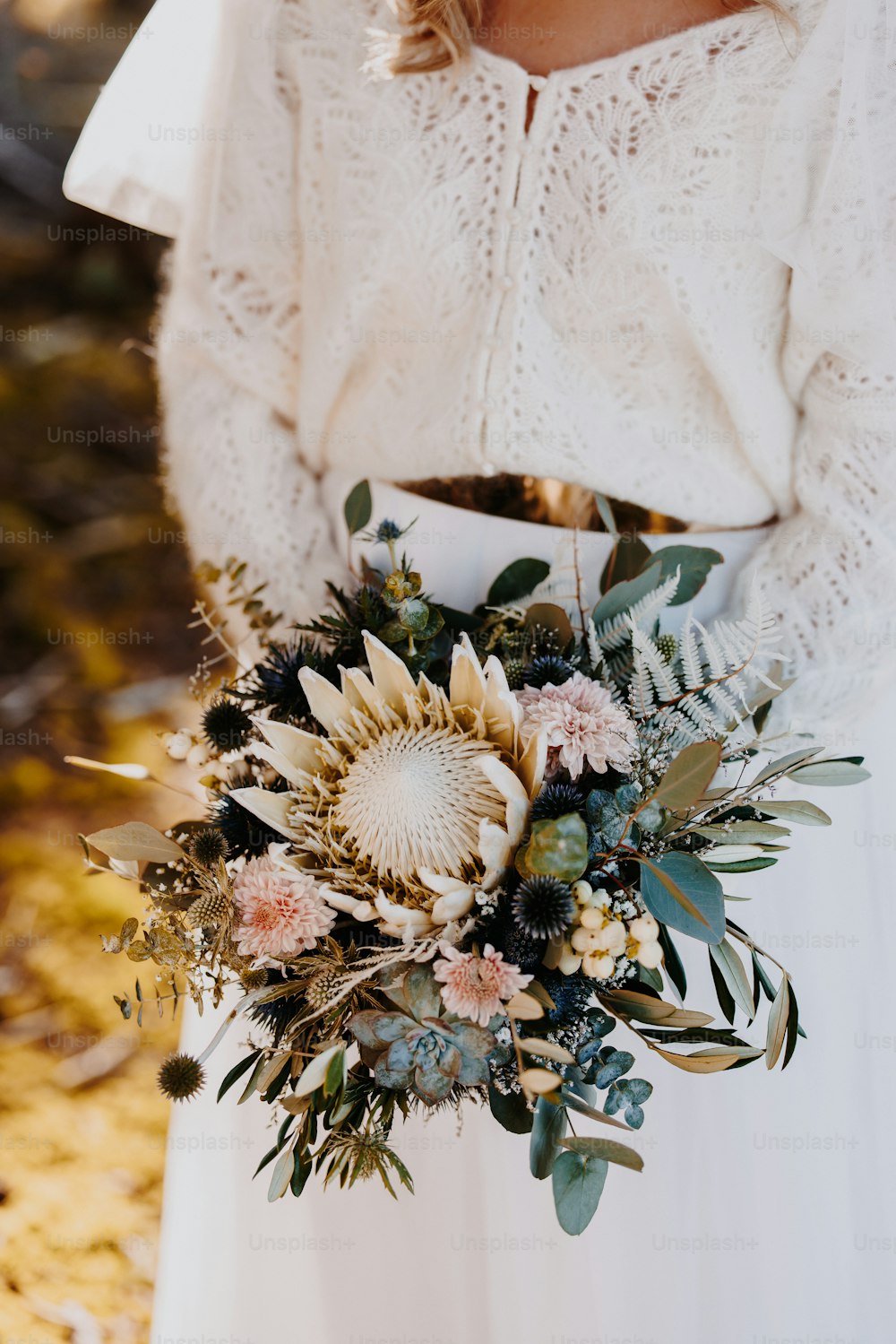 a woman in a white dress holding a bouquet of flowers