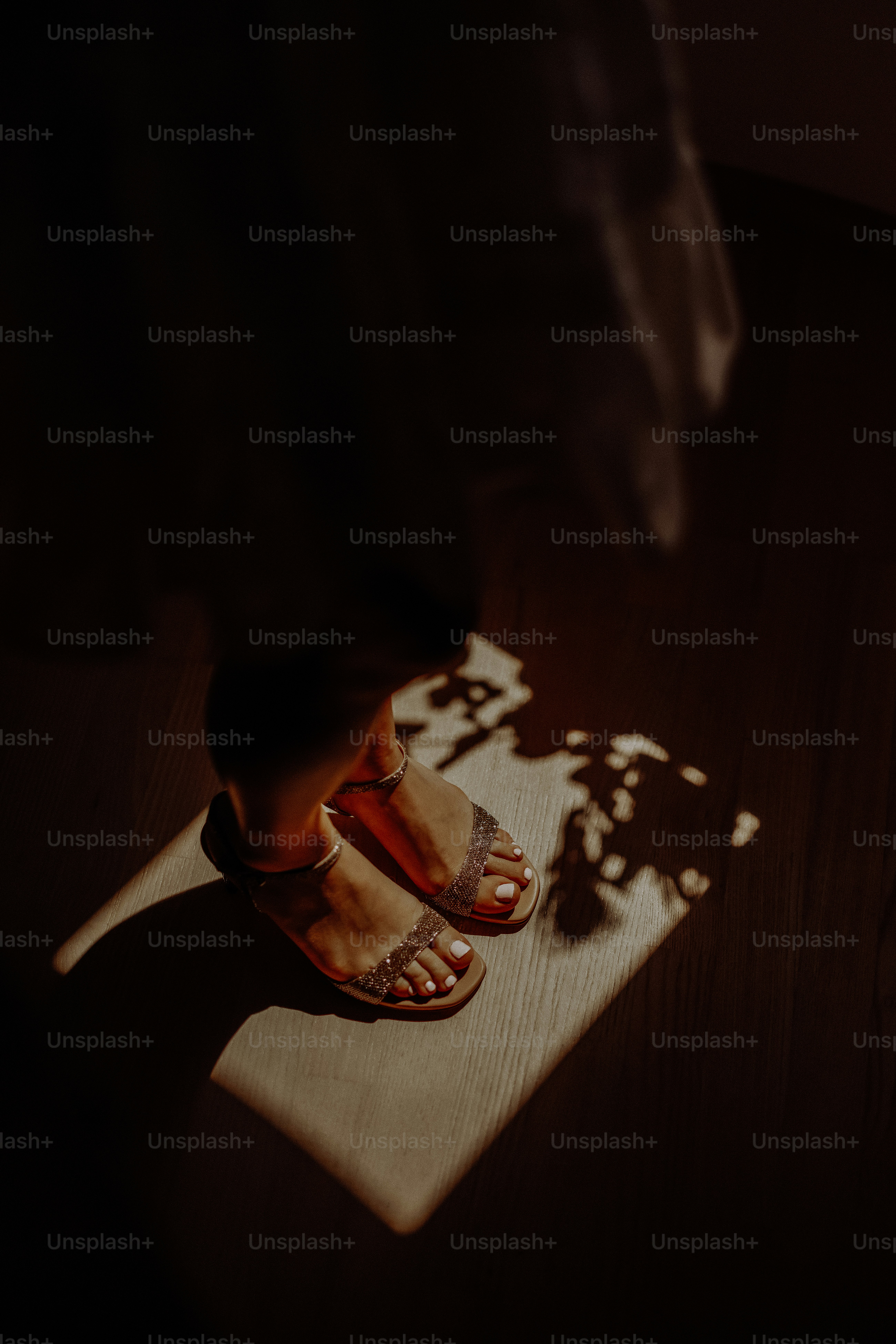 a person standing on a wooden floor in sandals