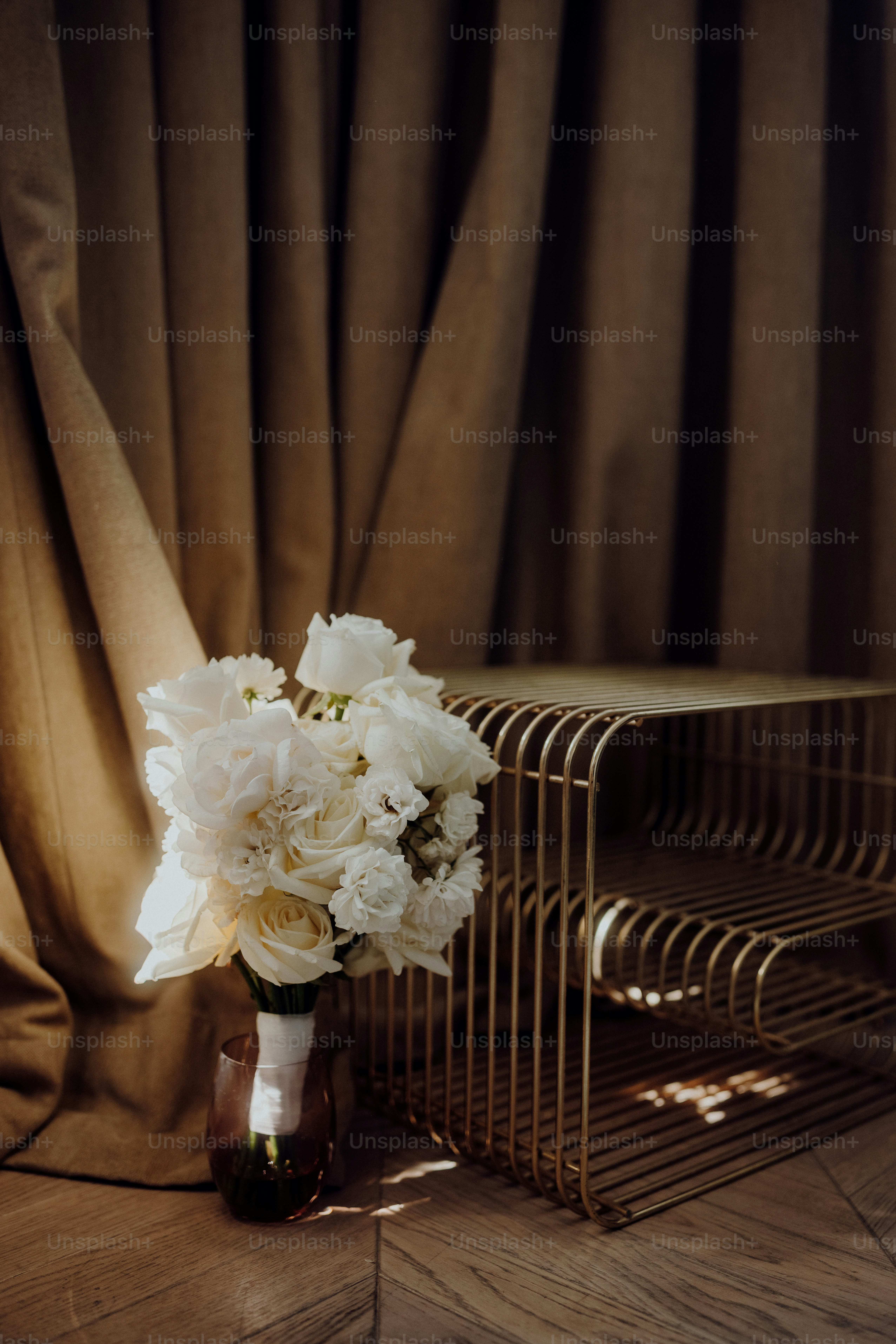 eine Vase mit weißen Blumen, die auf einem Tisch sitzt