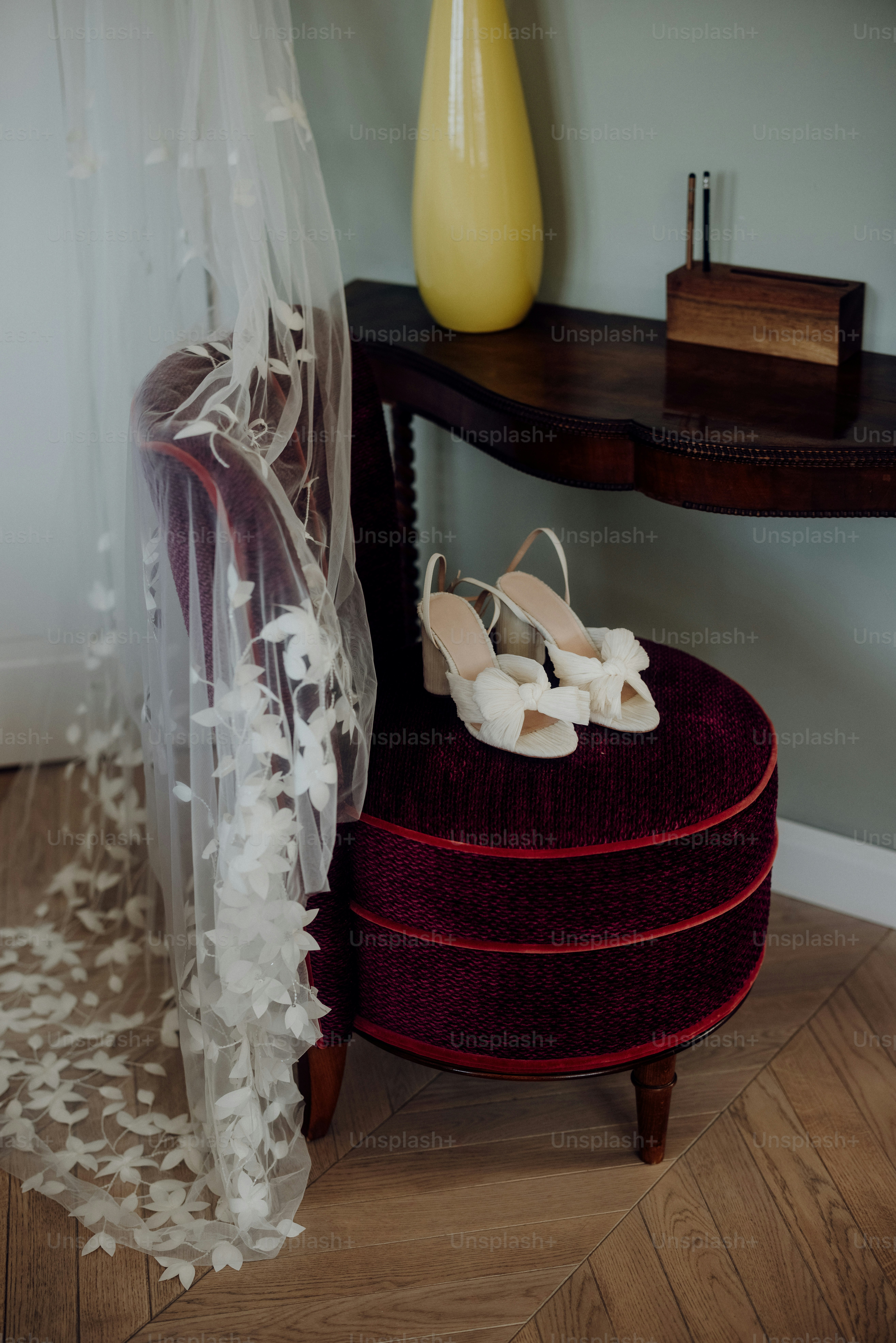 a pair of white shoes sitting on top of a red ottoman