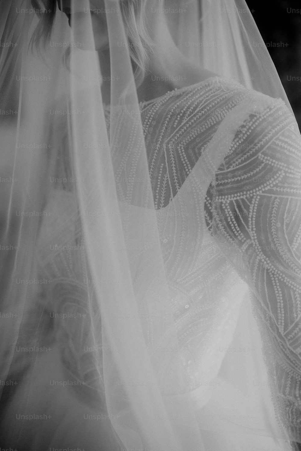 eine Frau in einem Hochzeitskleid mit einem Schleier über dem Kopf