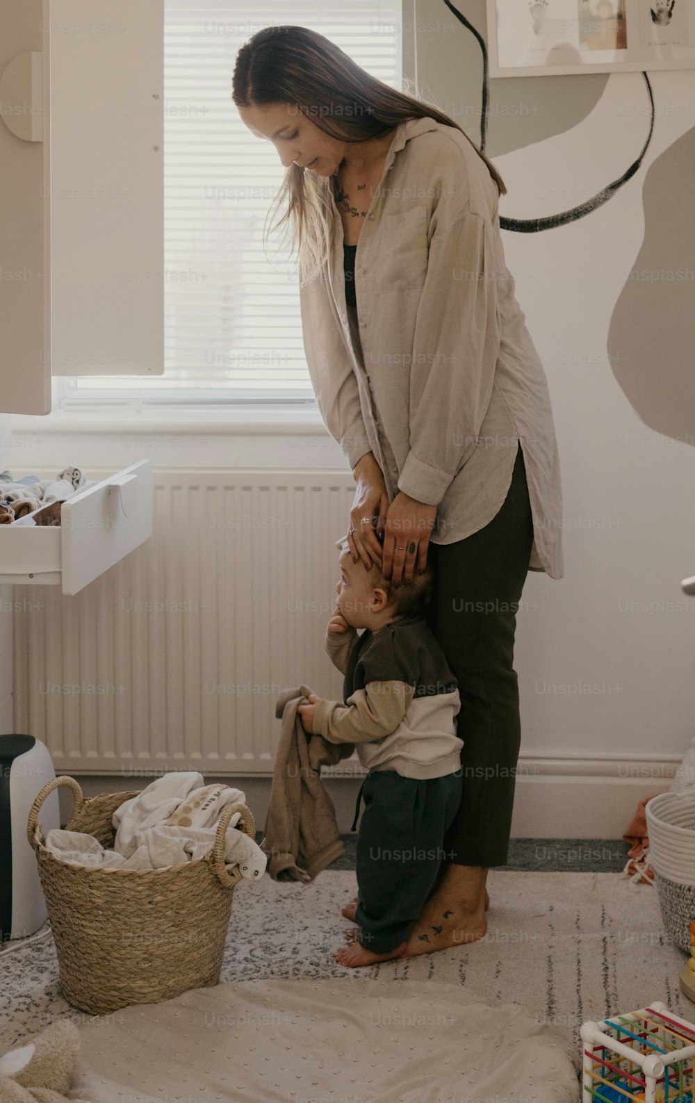 Una mujer de pie junto a un niño en una habitación