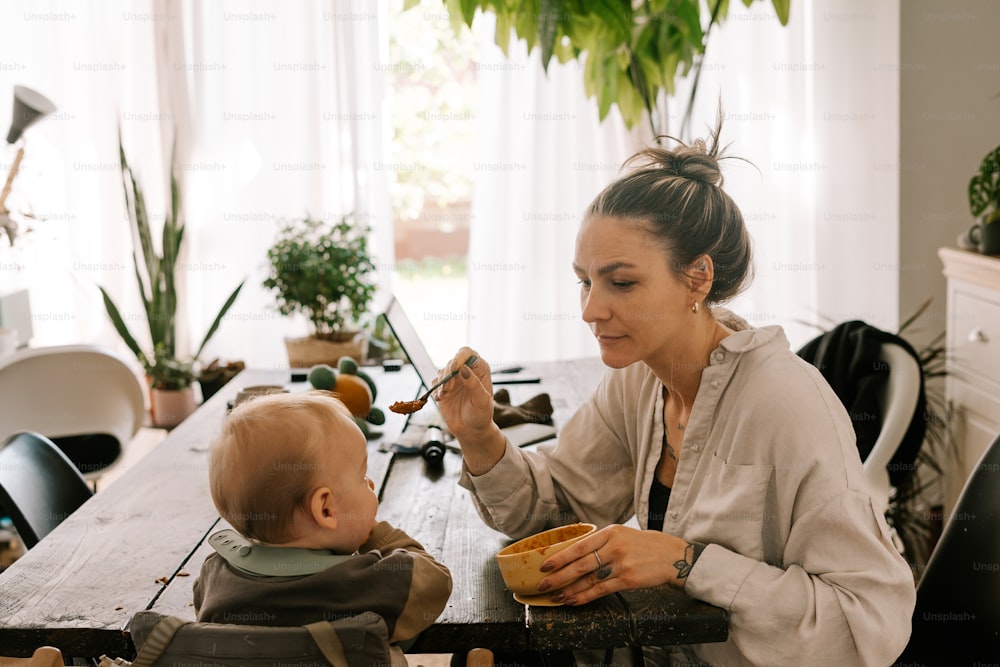 uma mulher alimentando um bebê com uma colher