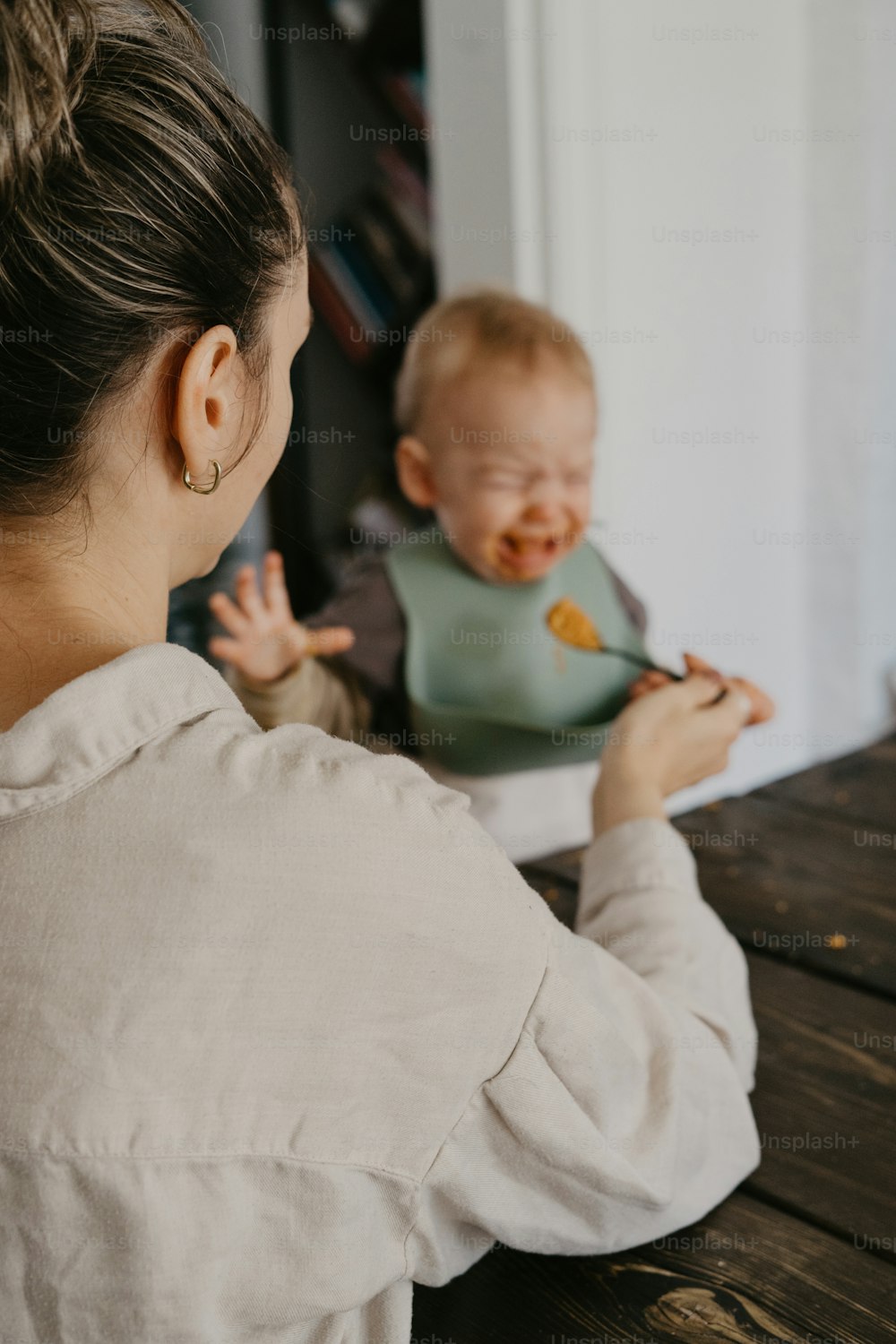 Eine Frau, die ein Baby hält, während sie isst;