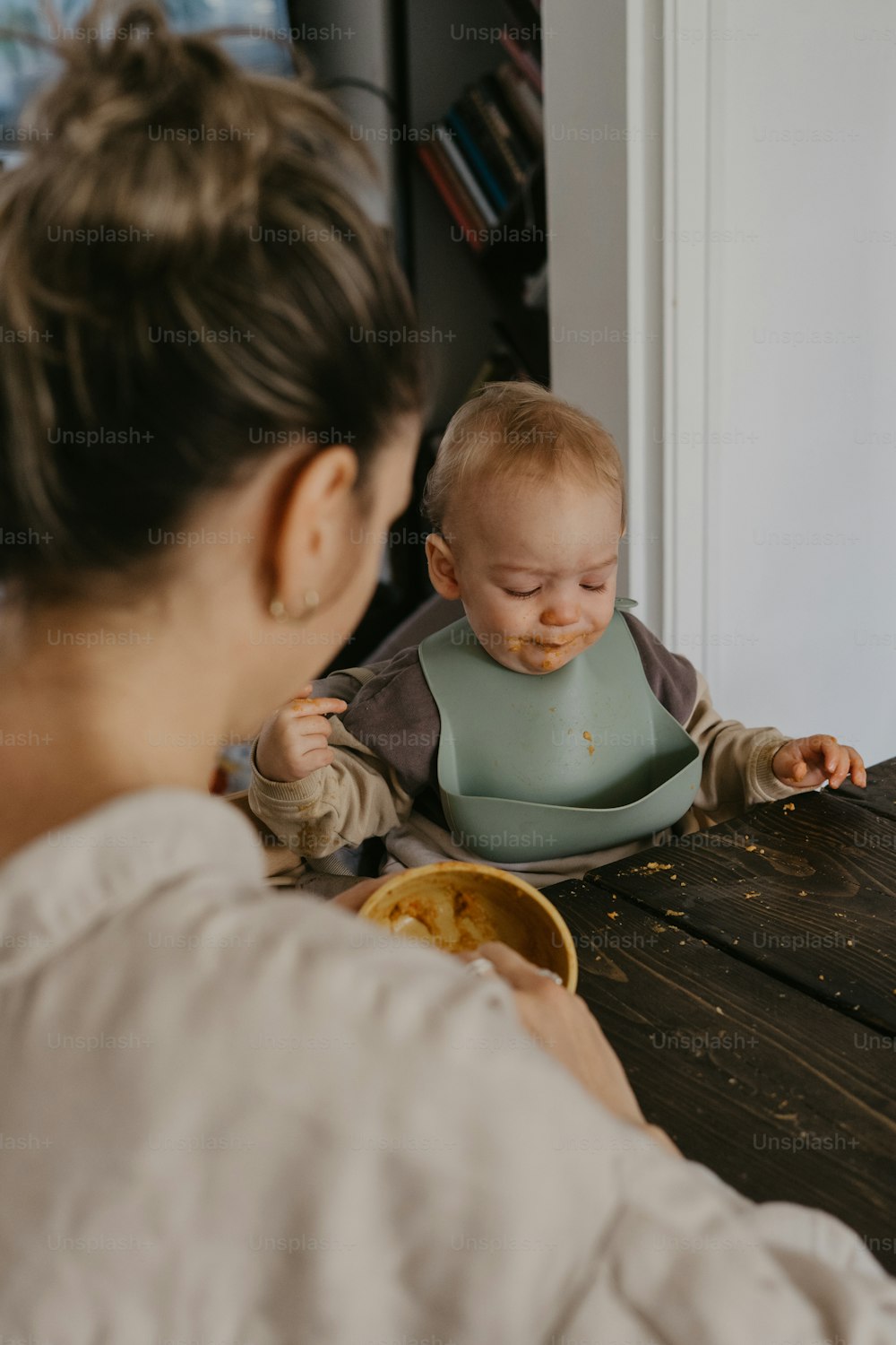 a woman feeding a baby with a spoon