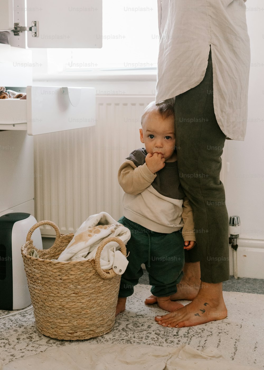a baby sitting on the floor next to a basket