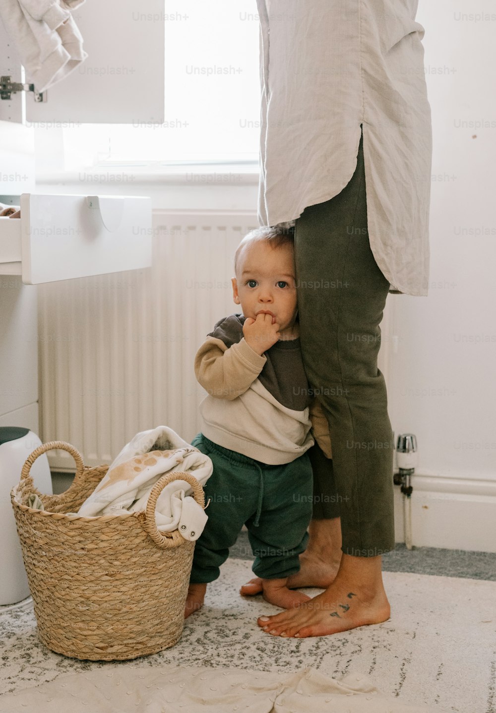 a baby sitting in a basket next to a person