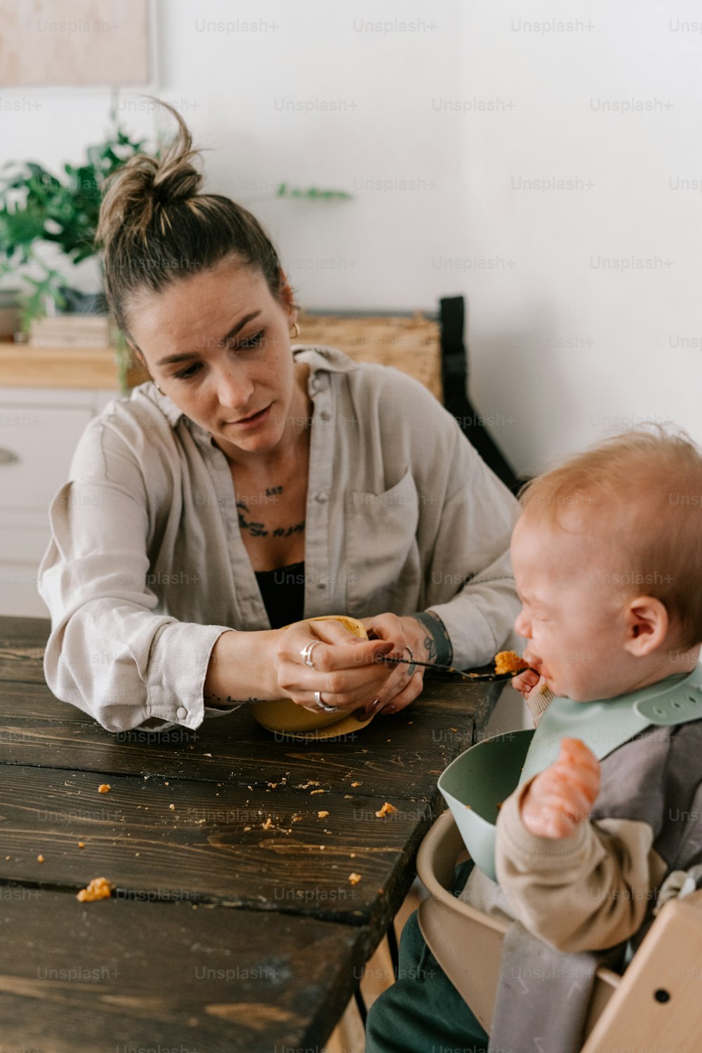 uma mulher alimentando um bebê com uma colher