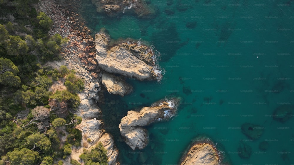 an aerial view of a body of water surrounded by rocks