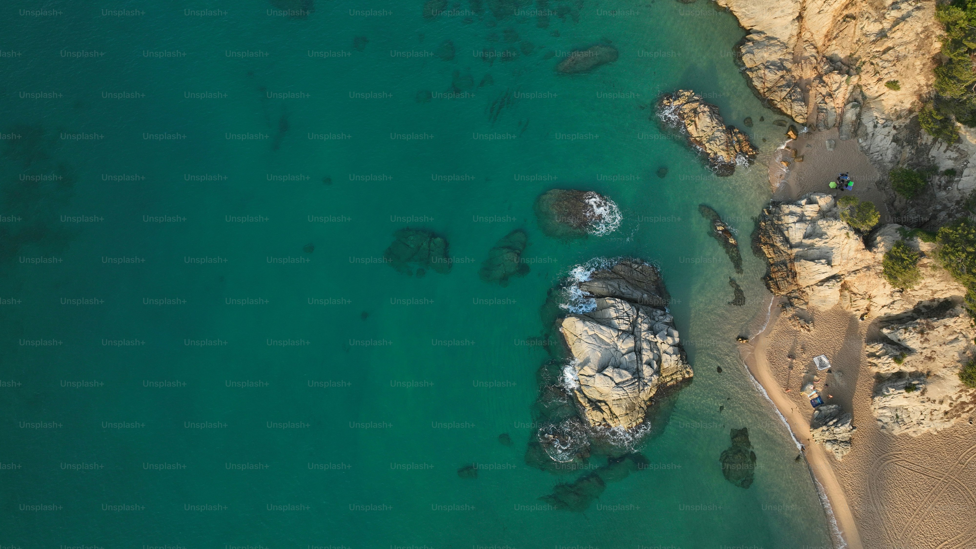 Eine Luftaufnahme eines Strandes mit Felsen und Wasser