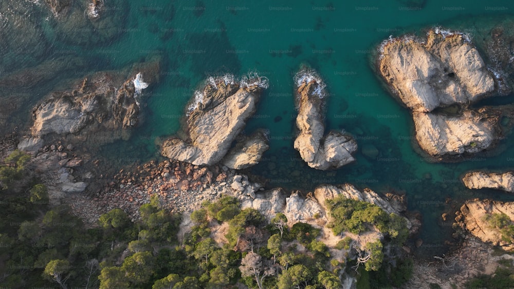 an aerial view of some rocks in the water