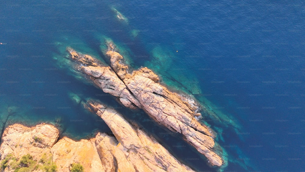 an aerial view of a rock outcropping in the ocean