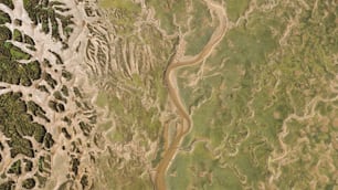 an aerial view of a river running through a lush green field