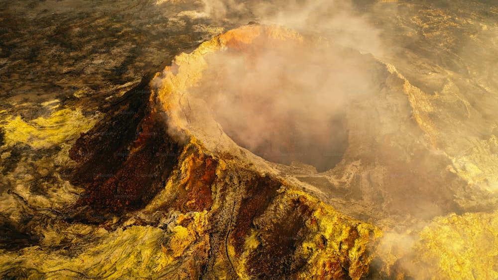 an aerial view of a crater with steam rising from it