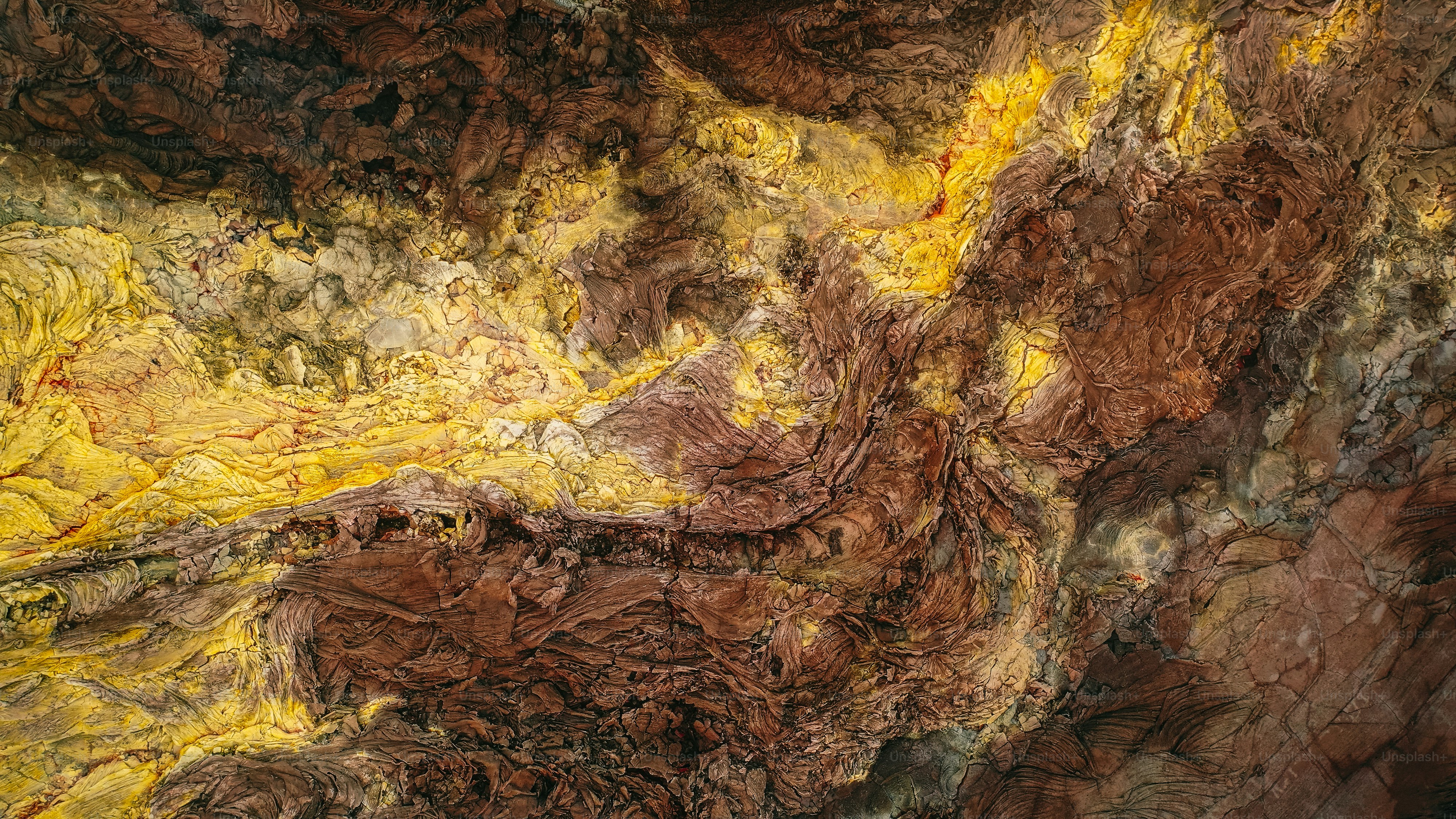a painting of brown and yellow colors on a wall