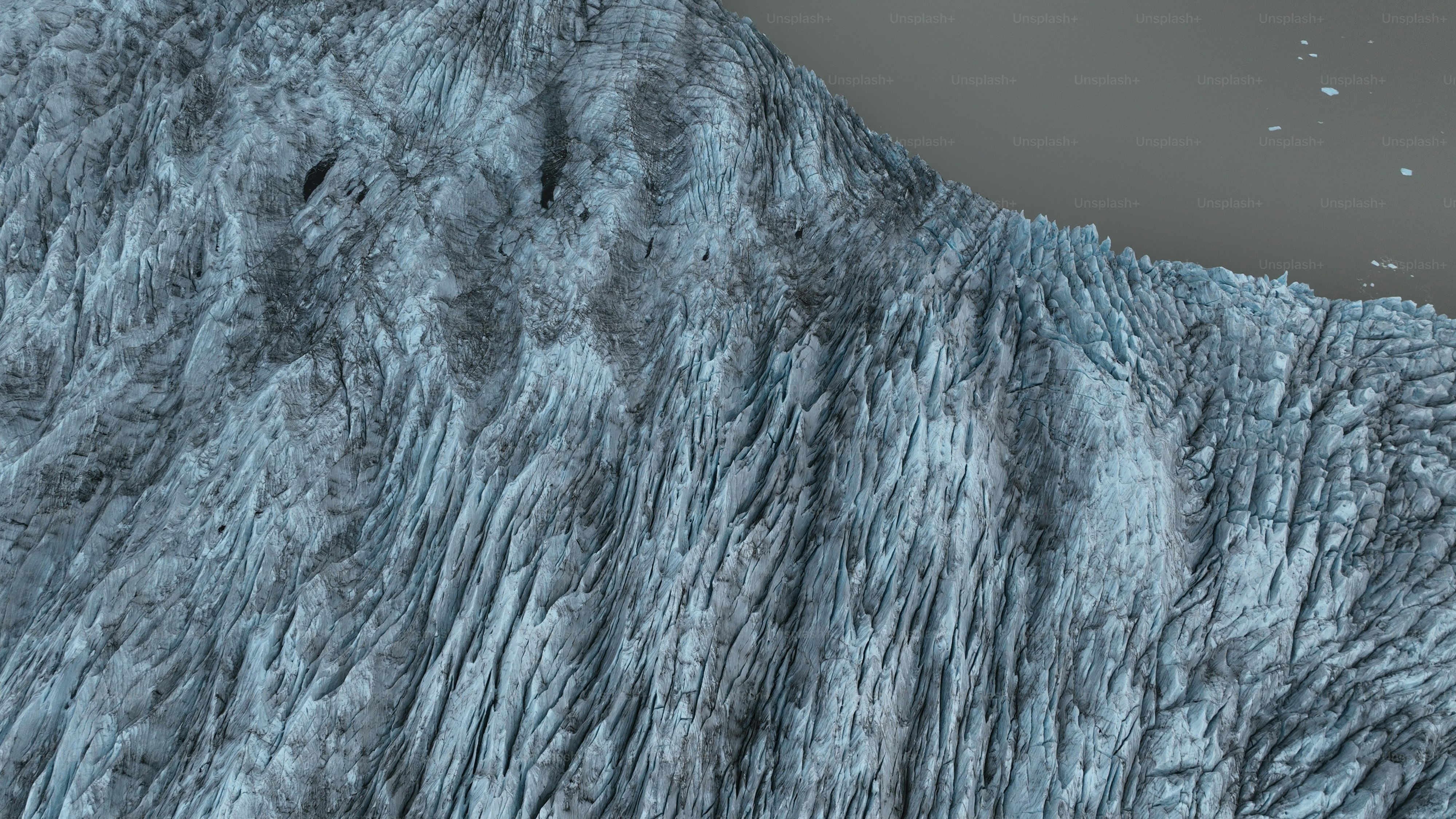 una parete glaciale molto grande con un uccello che vola sopra di essa
