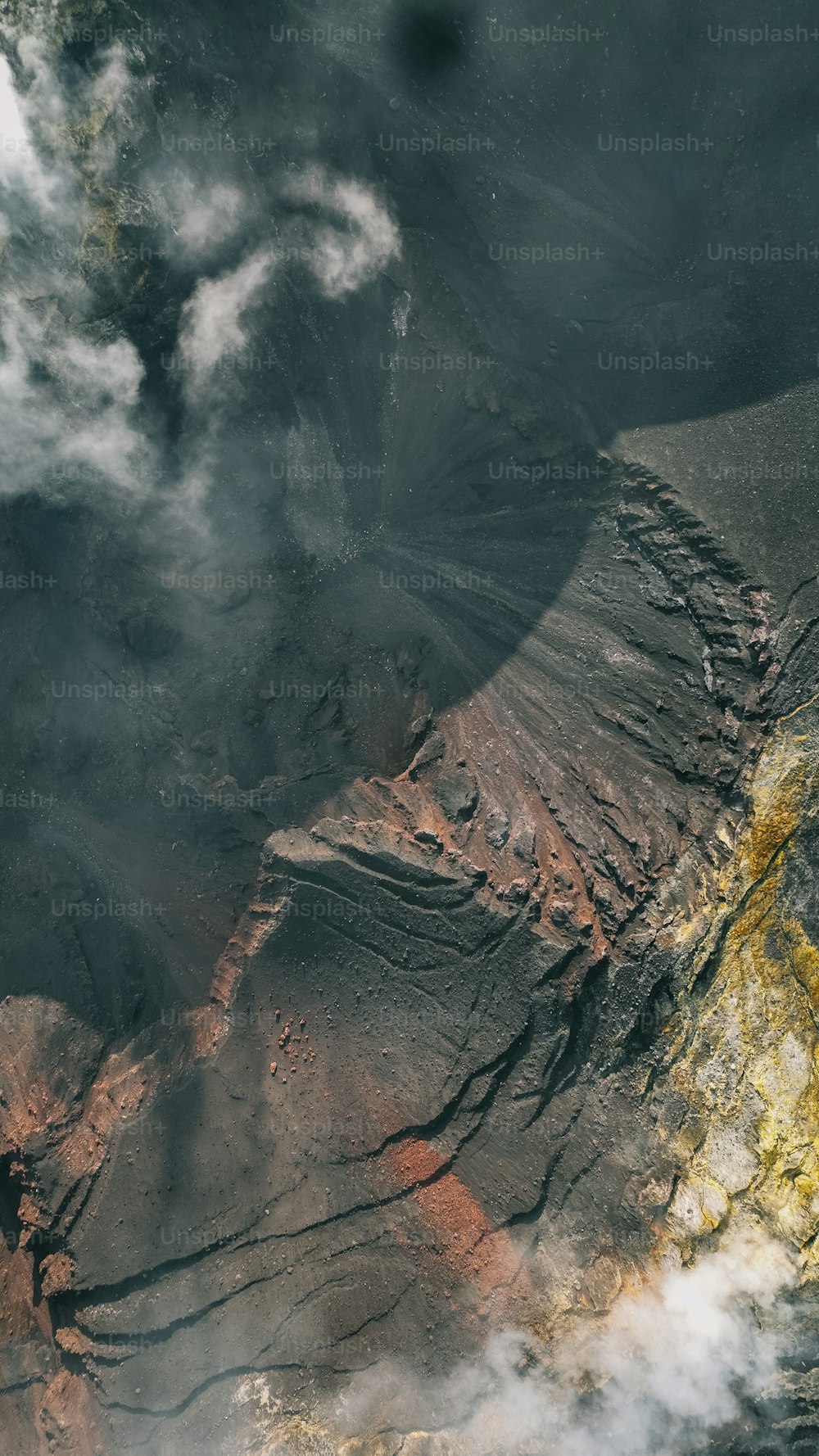 an aerial view of a mountain and clouds