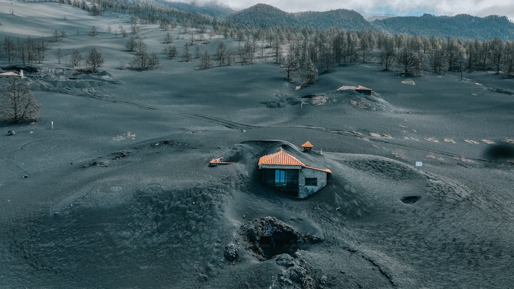 a small house in the middle of a snowy field