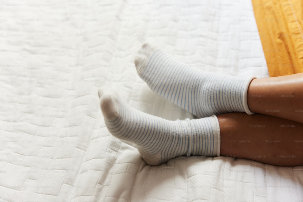 Una mujer sentada en una cama con las piernas cruzadas