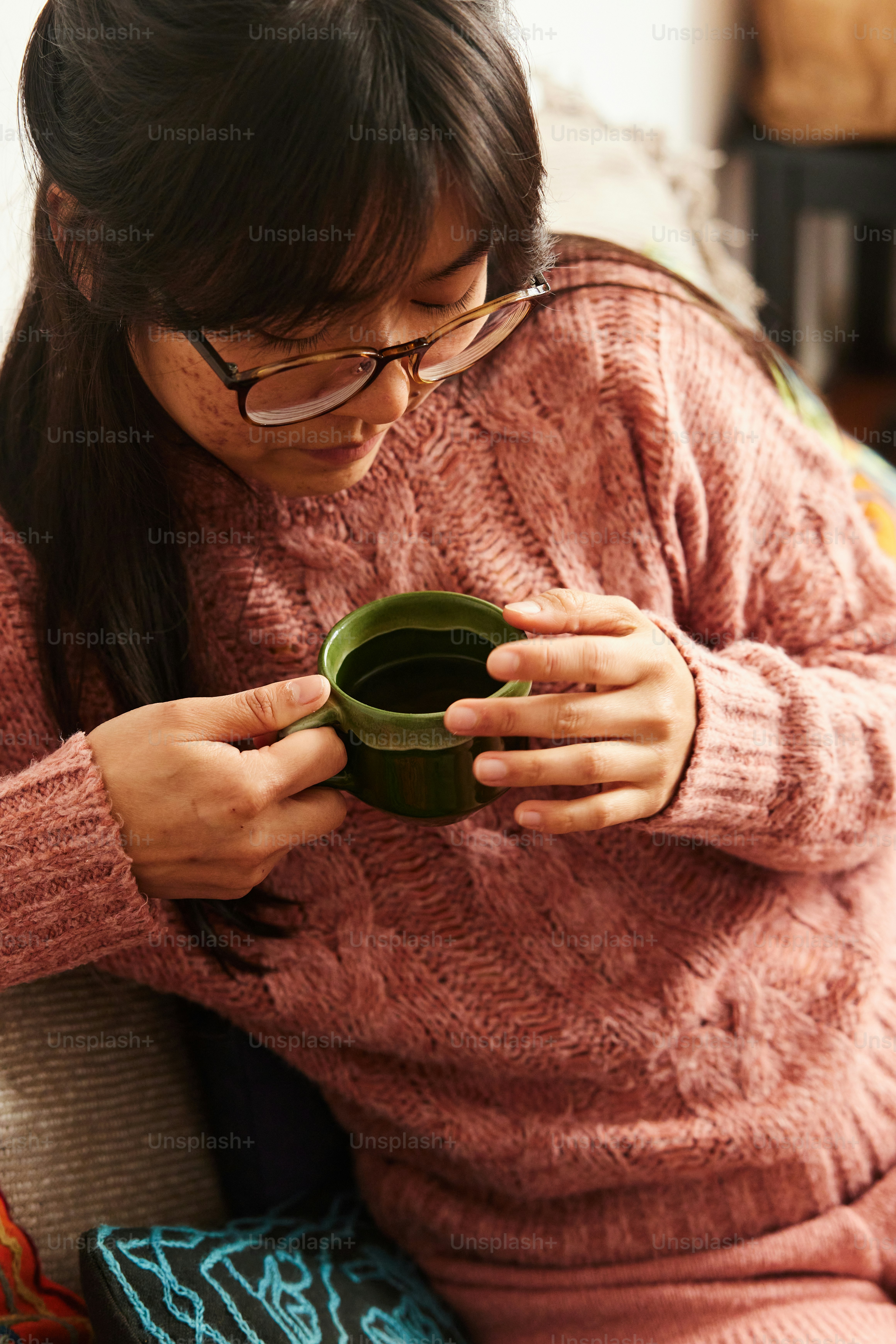 una donna seduta su un divano che tiene una tazza