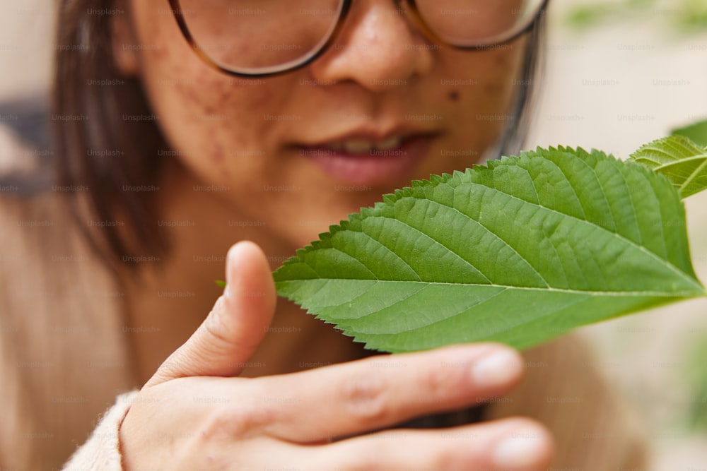 a close up of a person holding a leaf