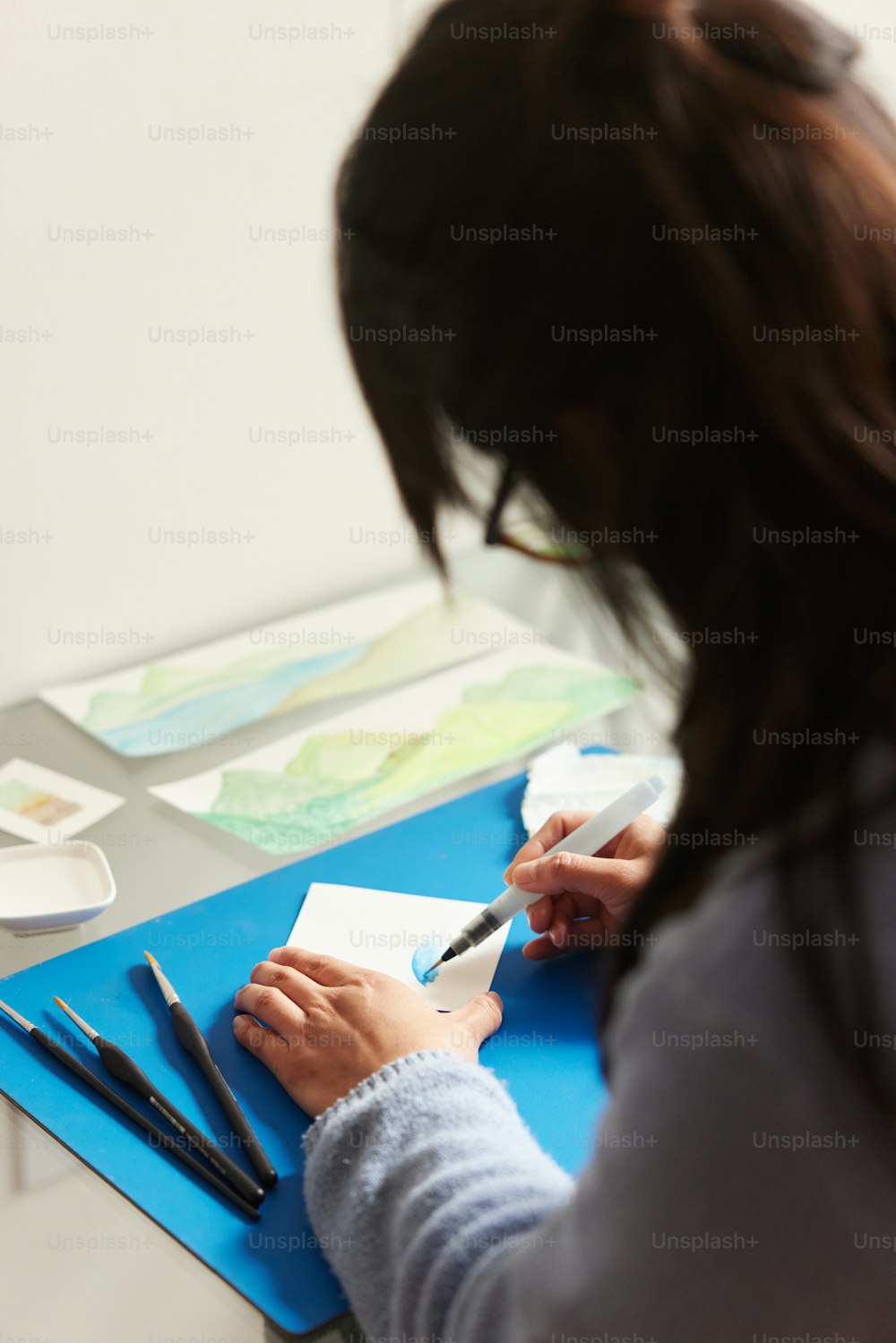 a woman sitting at a desk writing on a piece of paper