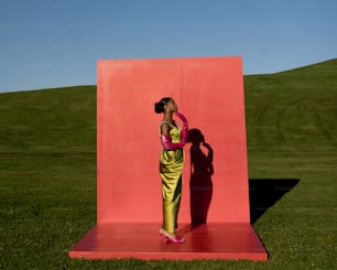 Une femme debout devant un mur rouge