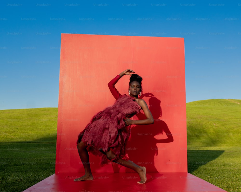 a woman standing in front of a red wall