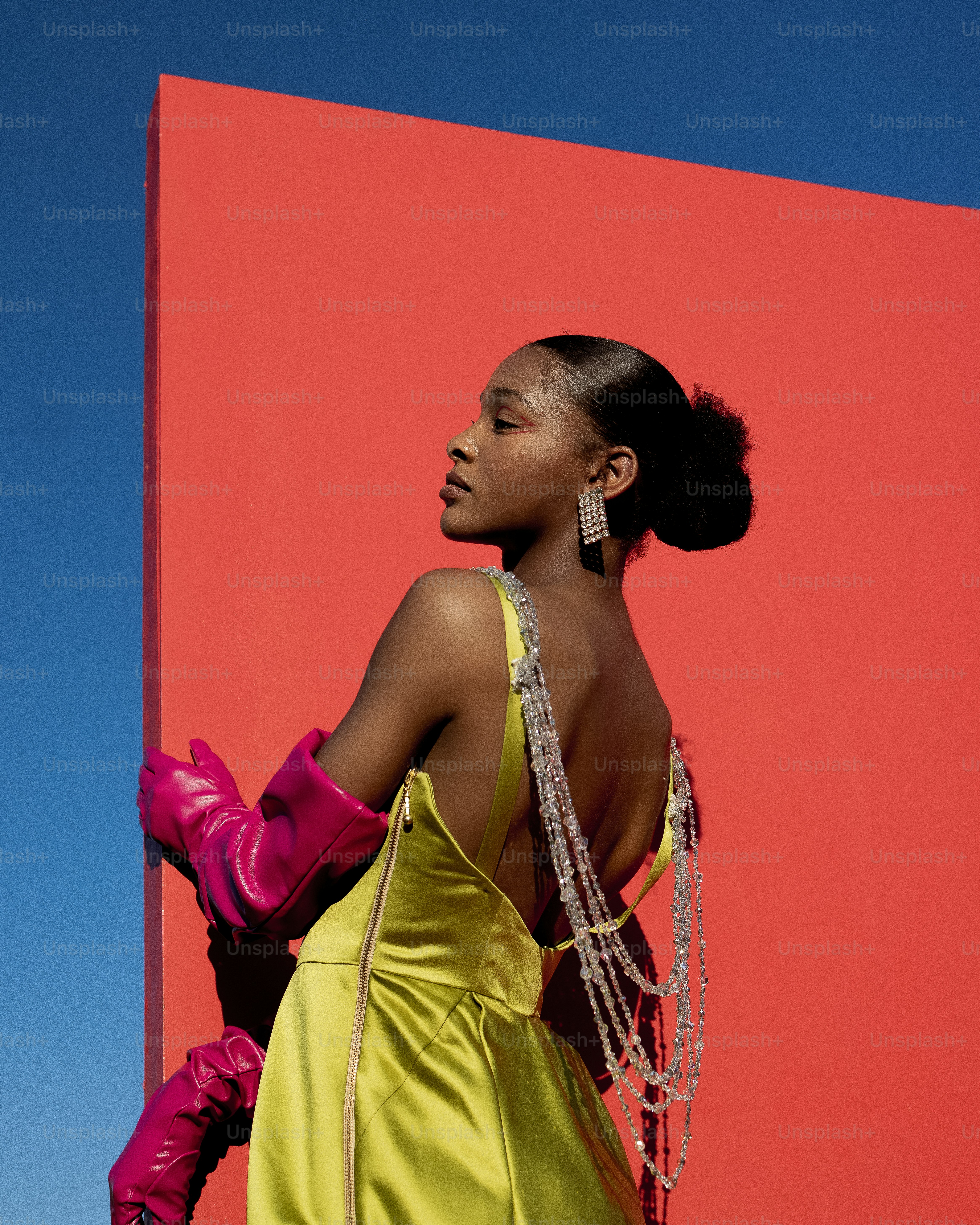 a woman in a yellow dress and pink gloves