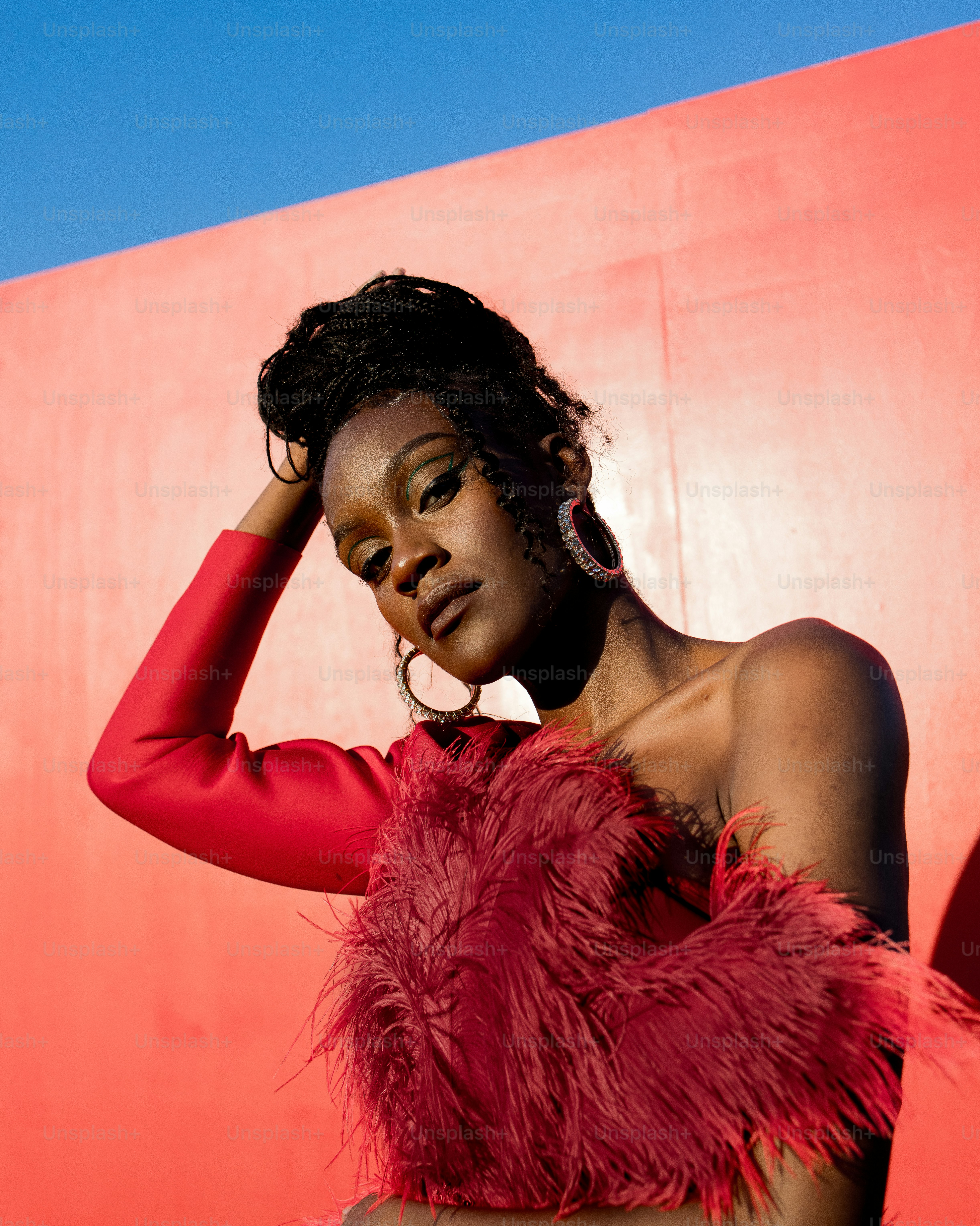 a woman in a red feathered dress poses for a picture