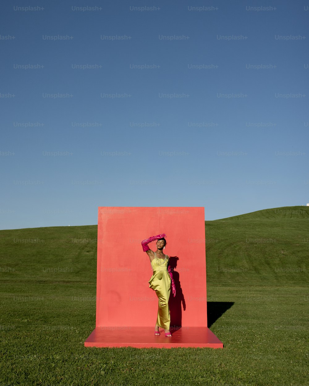 a woman standing in front of a pink sculpture