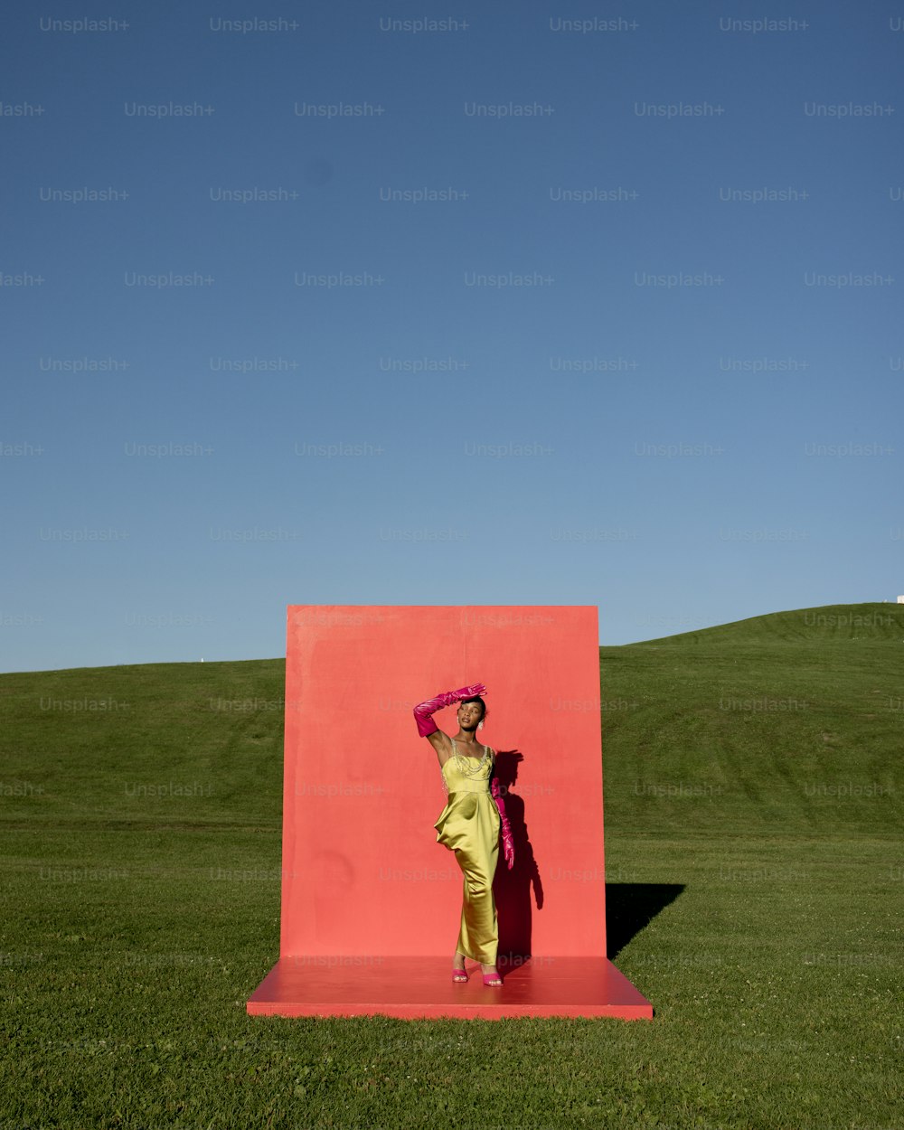 분홍색 조각상 앞에 서 있는 여자