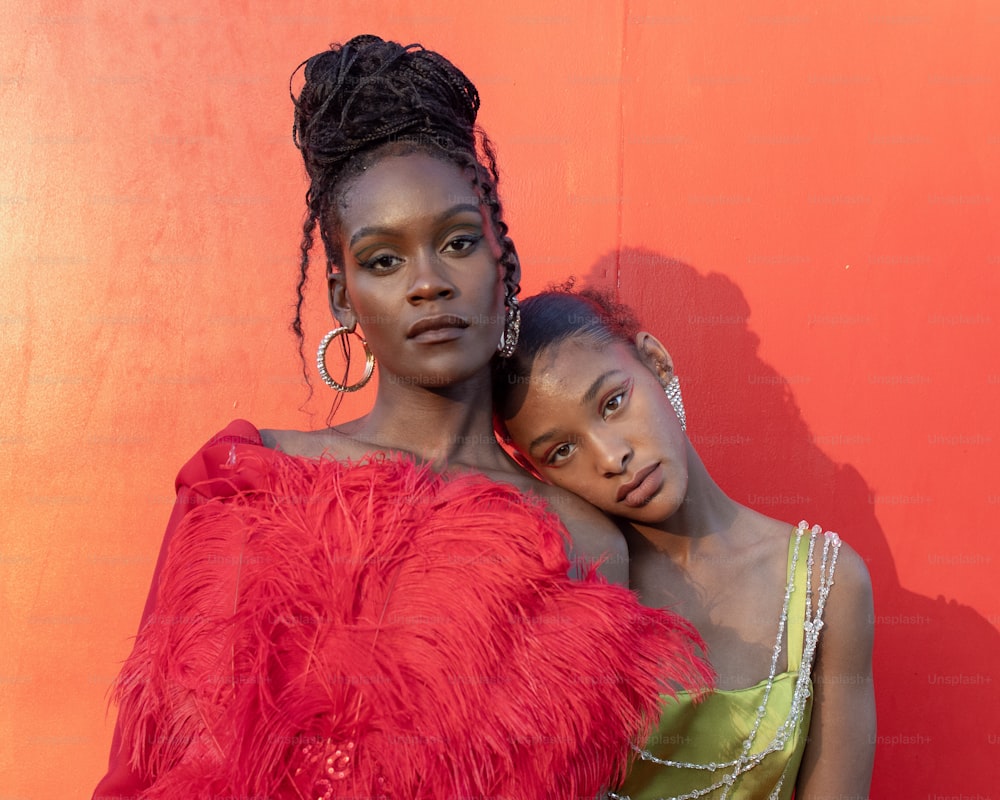 two women in red and green dresses standing next to each other