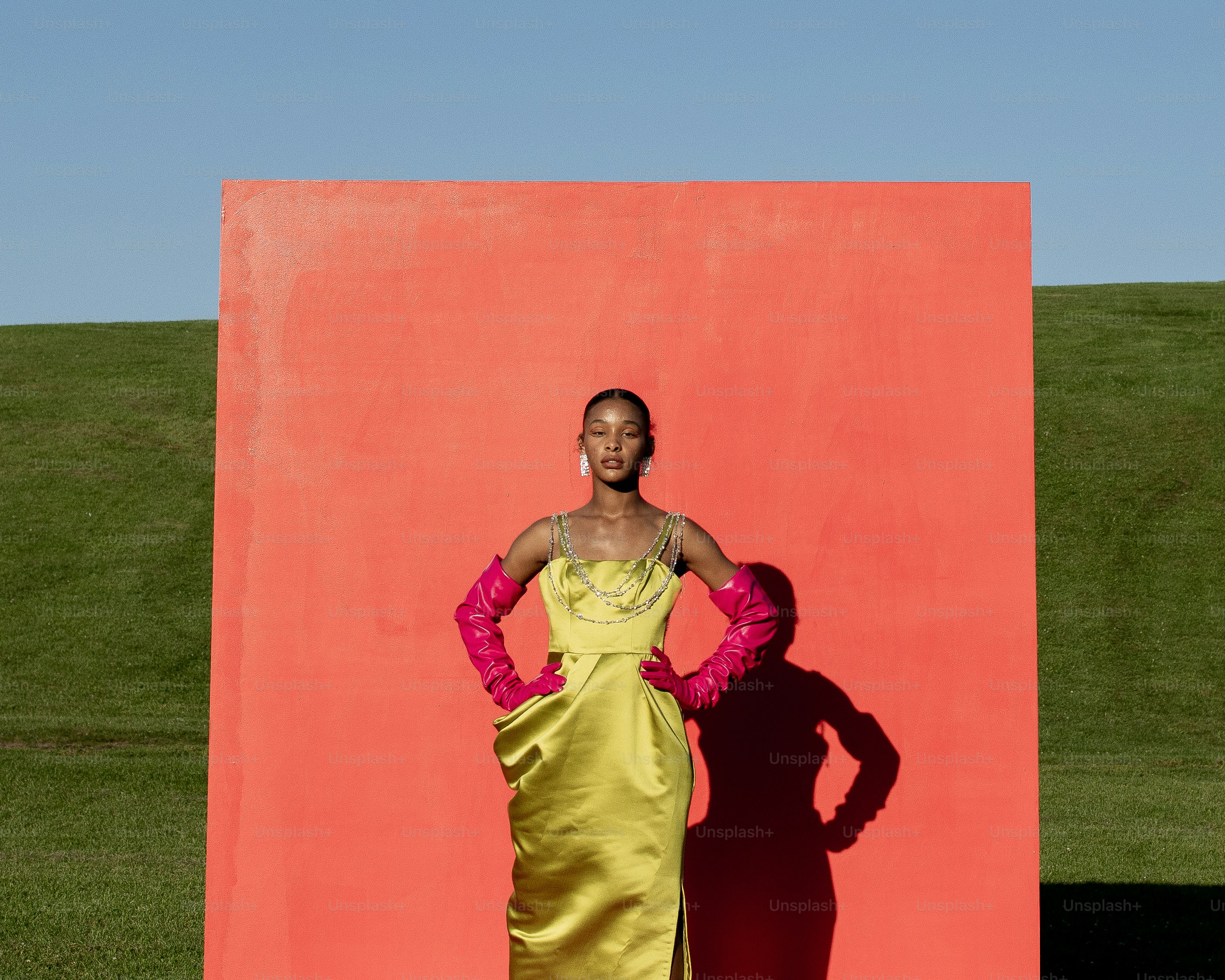 Une femme debout devant un mur rouge et orange