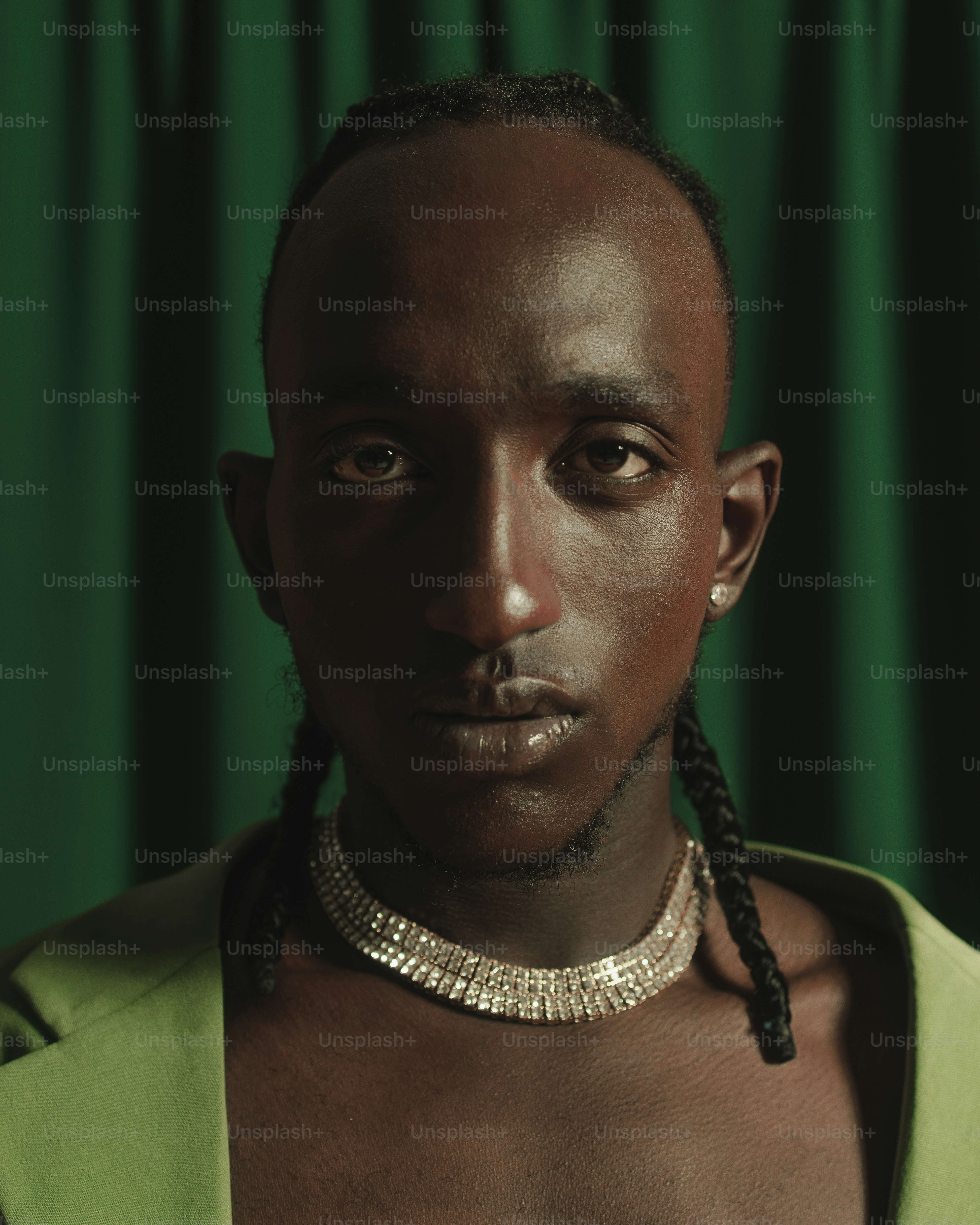 a black man with braids and a green shirt