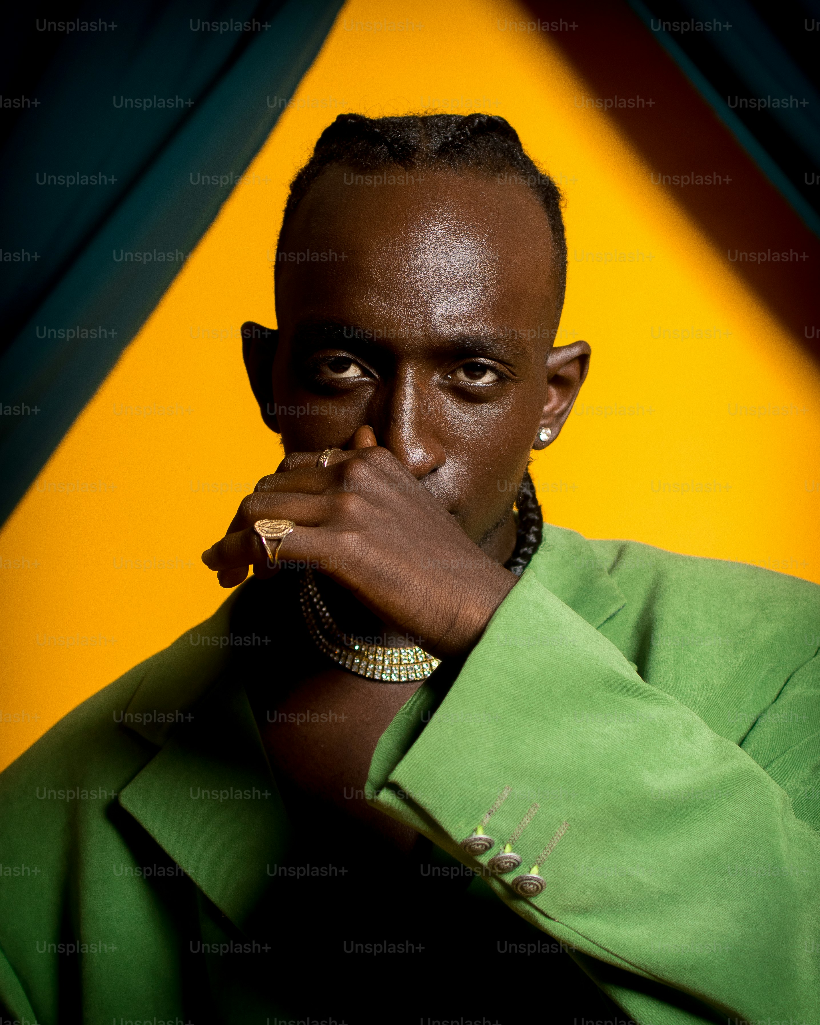 a man in a green shirt is holding his hand to his mouth