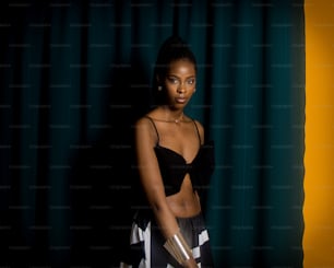 a woman standing in front of a green curtain