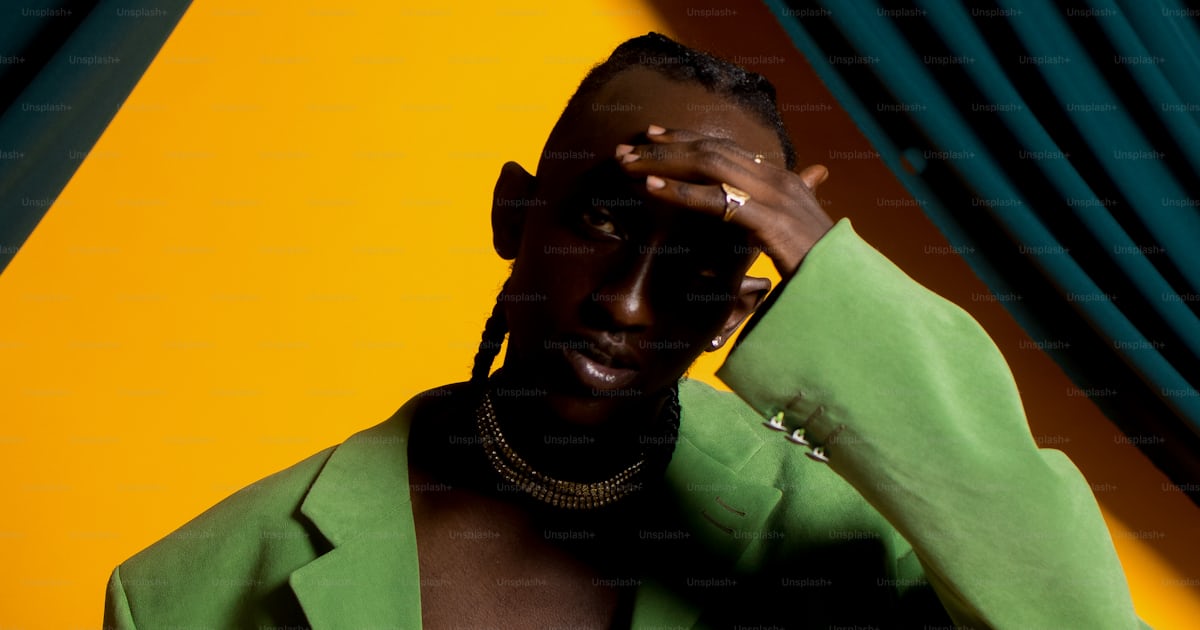 A man in a green suit is covering his eyes photo – Fashion Image on