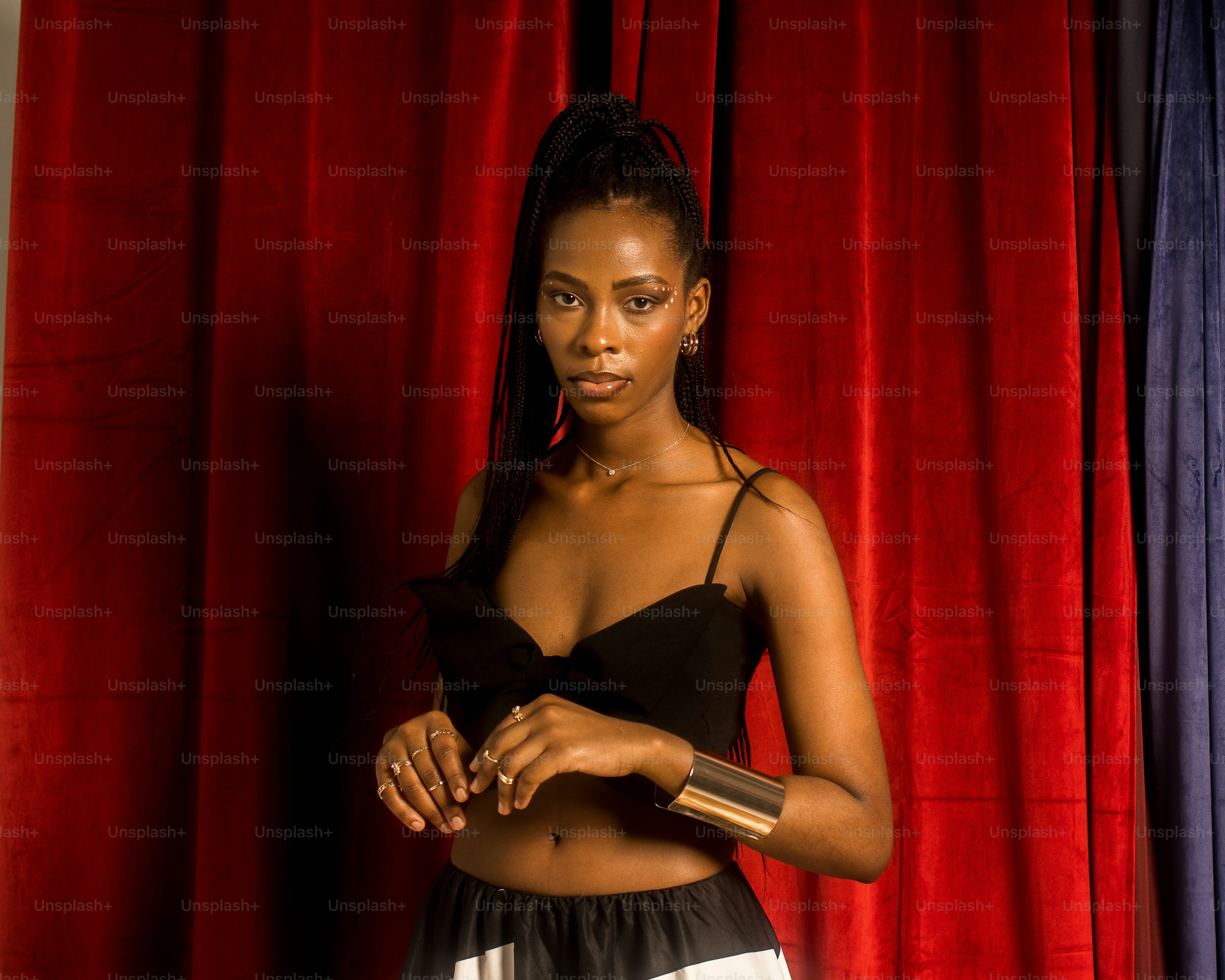 a woman standing in front of a red curtain