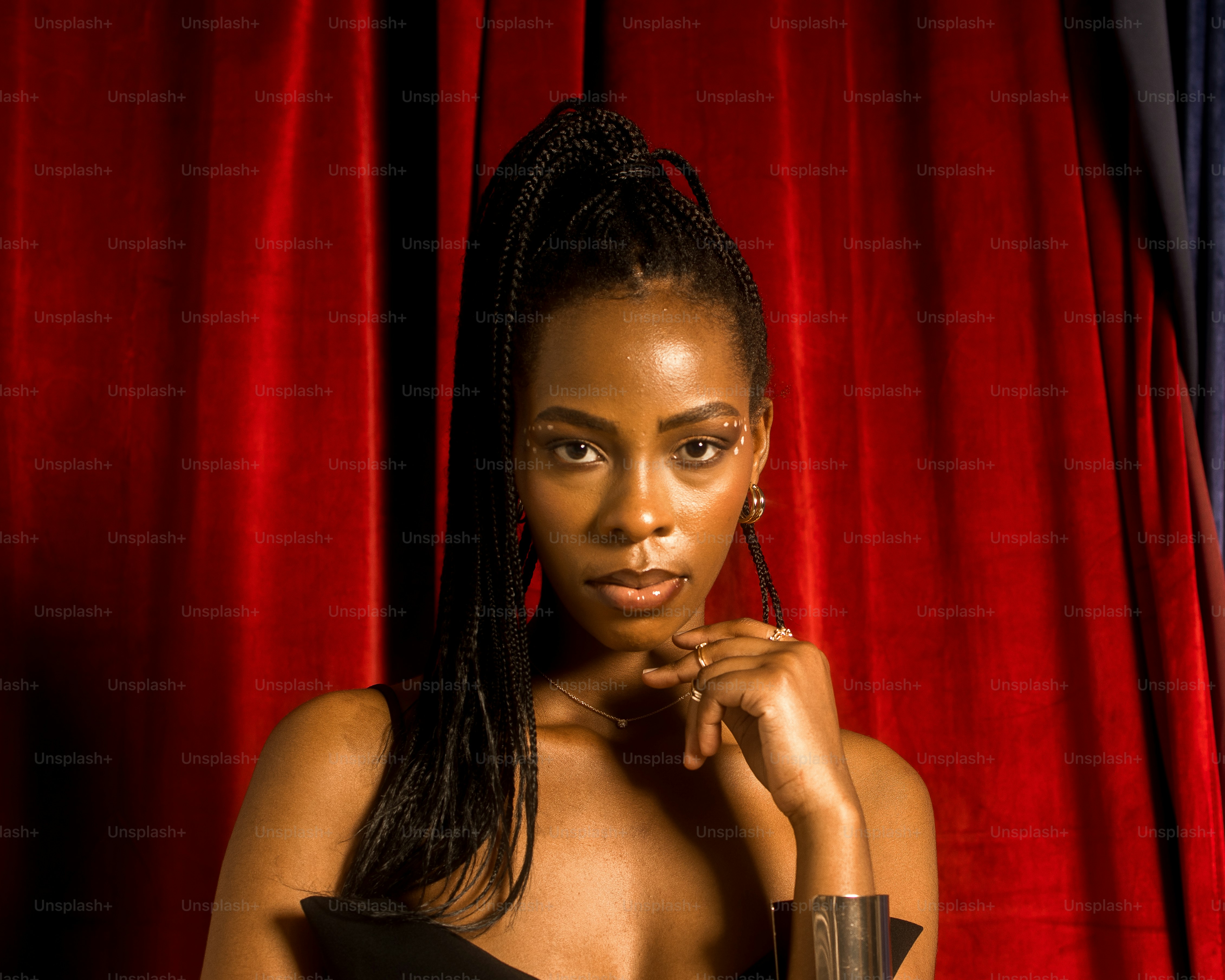 a woman posing for a picture in front of a red curtain