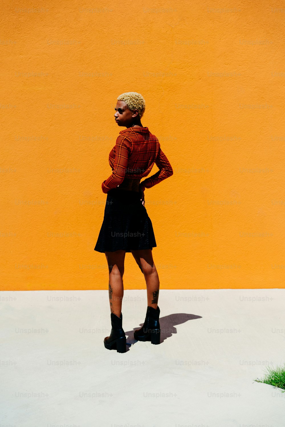 Eine Frau, die vor einer gelben Wand steht