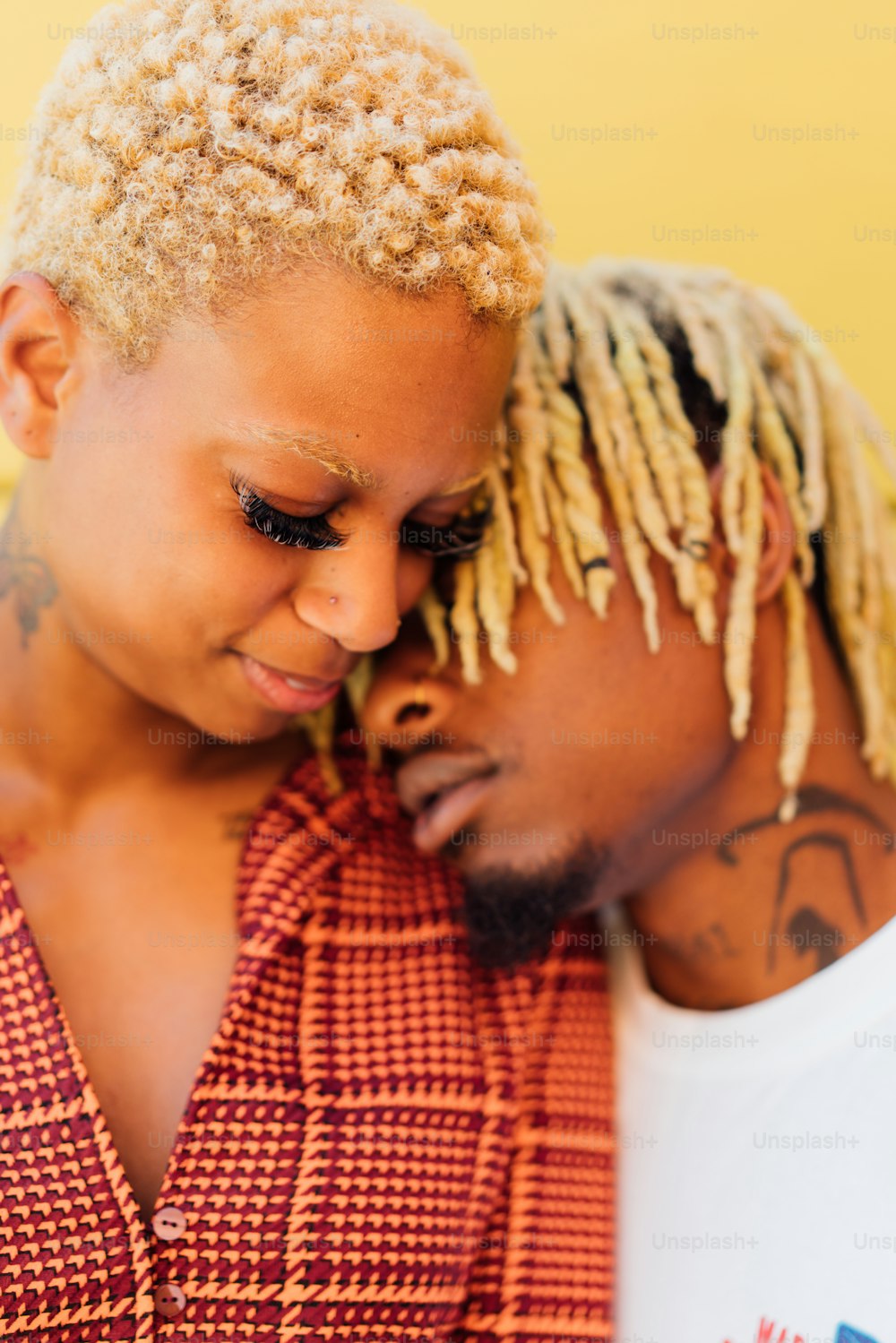 a man and a woman with dreadlocks looking at a cell phone